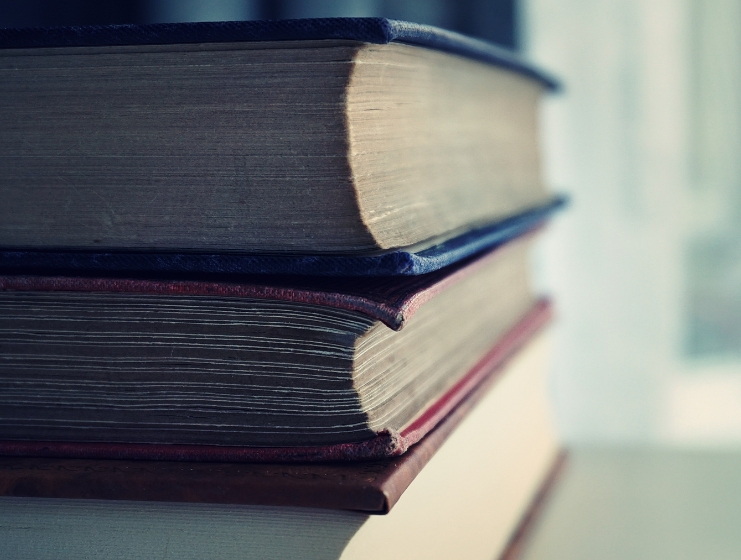 A close-up of a stack of thick hardcover textbooks